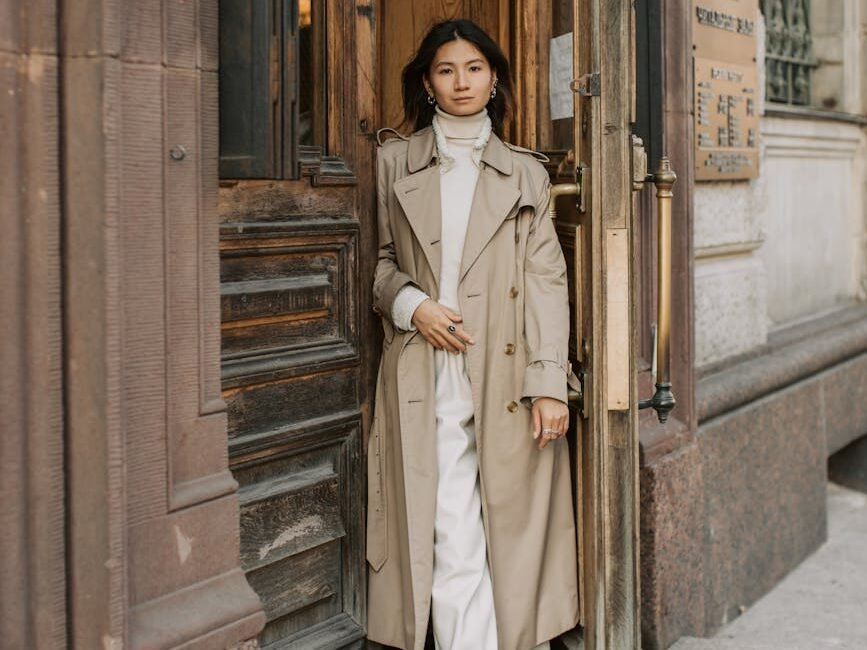 woman in brown trench coat standing beside brown wooden door